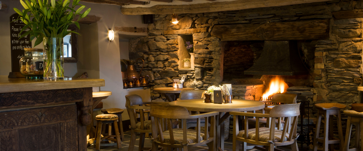 Cosy dining room with real wood fire at The Queen's Head Troutbeck in the Lake District, Cumbria
